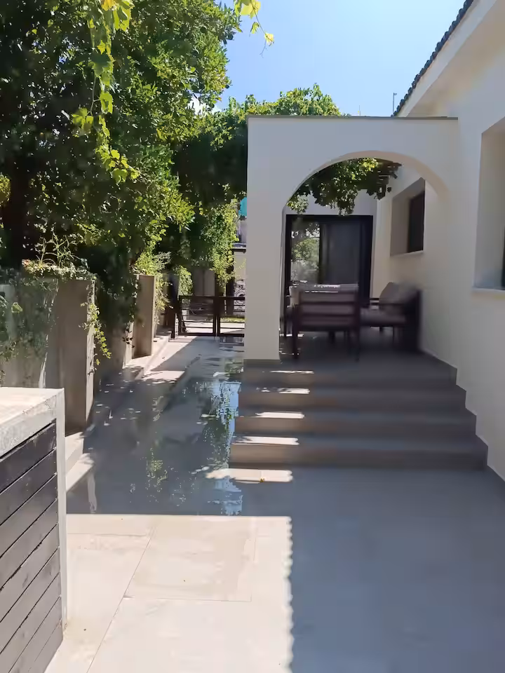 Arched garden walkway shaded by grapevines