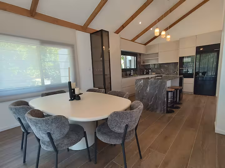 Open kitchen with marble island and beamed ceiling